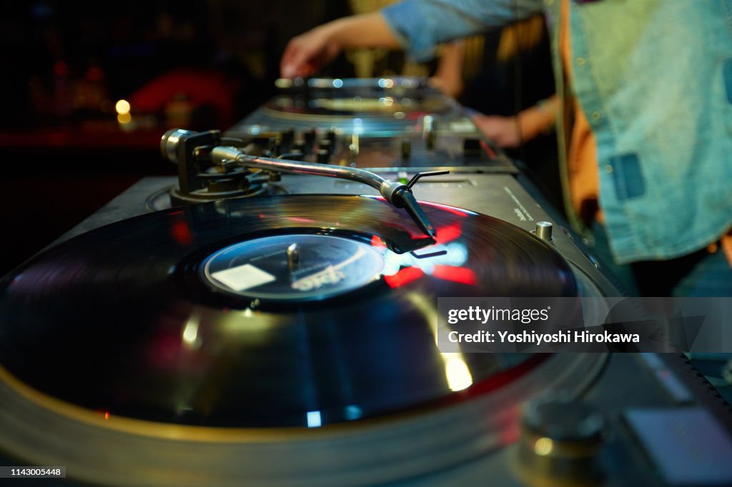 Closeup shot of DJ mixing music on turntable.