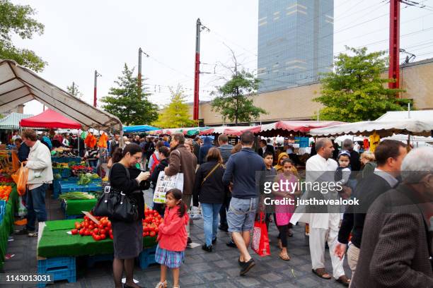 many people on multi-ethnic weekend market - adult man brussels stock pictures, royalty-free photos & images
