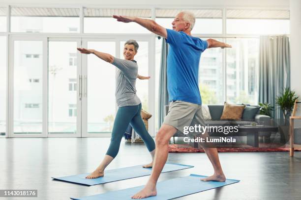 gemeinsam durch fitness und gesundheit - senior yoga stock-fotos und bilder