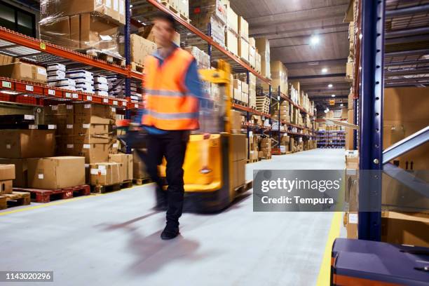 entrepôt, ouvrier avec un chariot élévateur en mouvement flou. - warehouse worker photos et images de collection