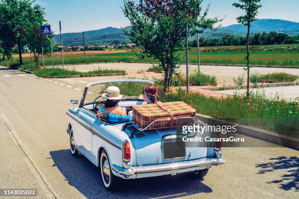 mature women on a road trip with old-fashioned convertible - take a vintage summer road trip stock pictures, royalty-free photos & images