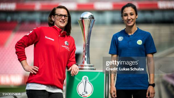 Jobina Lahr of SC Freiburg and Sara Doorsoun of Wolfsburg pose with the trophy during a press conference ahead of the Women's DFB Cup Final on April...
