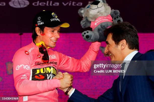 Italian businessman Urbano Cairo congratulates Slovenia's Primoz Roglic, wearing the overall leader's pink jersey, as he Urbano Cairocelebrates on...