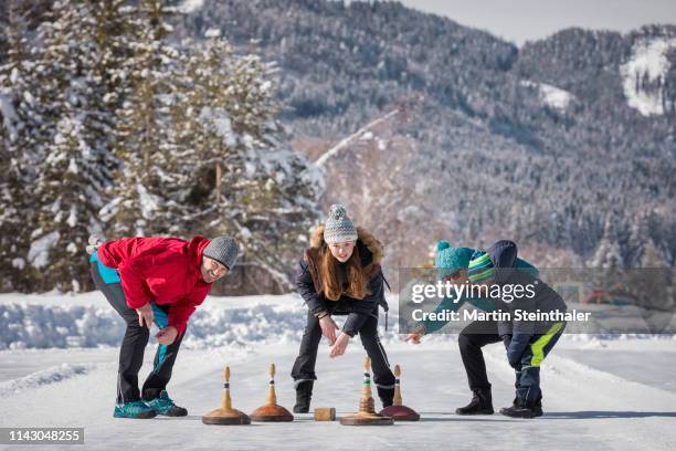 familie beim eisstock schießen am weissensee - winter tourismus - カーリング ストックフォトと画像