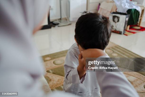 zoon op zoek naar vergiffenis voor zijn moeder op de eid mubarak - eid mubarak stockfoto's en -beelden