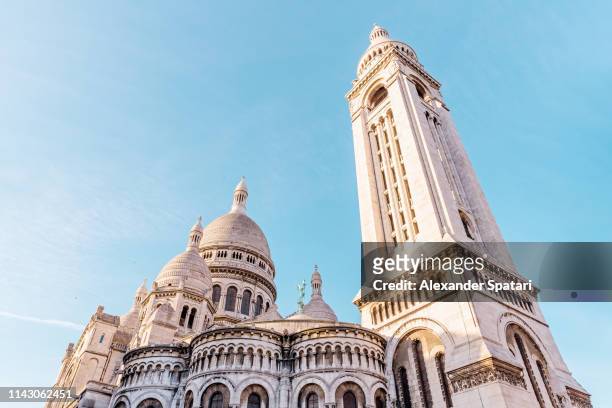 low angle view of sacre coeur basilica in montmartre against clear blue sky, paris, france - sacré coeur paris stock pictures, royalty-free photos & images