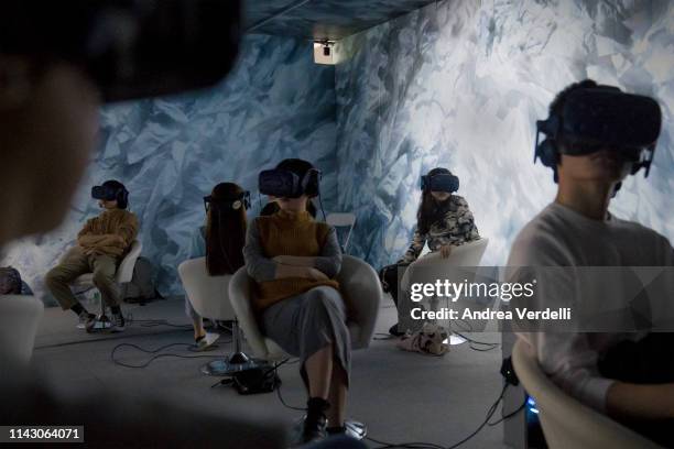 People watch a virtual reality film during a show organized for the Beijing International Film Festival on April 16, 2019 in Beijing, China. The...