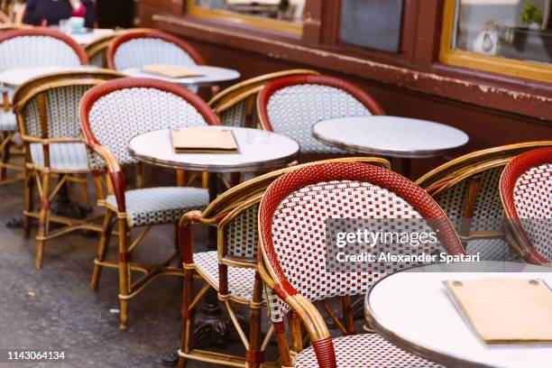 chairs and table in a traditional parisian sidewalk cafe - cafe table chair outside stock pictures, royalty-free photos & images