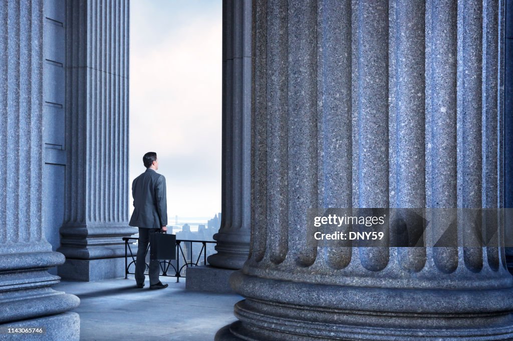 Lawyer Or Businessman Standing In Portico Of Greek Columns
