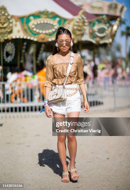 Jaime Xie is seen wearing white Prada bag, beige blouse, white shorts at the Revolve Festival during Coachella Festival on April 14, 2019 in La...