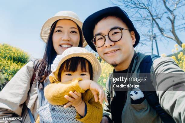happy family of three having fun and enjoying family time in oilseed rape field on a lovely sunny day - self portrait stock pictures, royalty-free photos & images