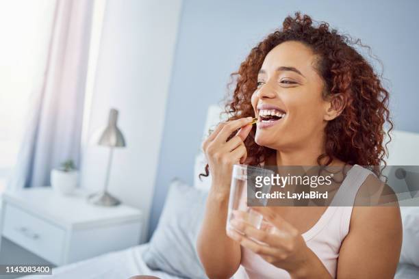 taking her daily medication with a smile - moving activity stock pictures, royalty-free photos & images