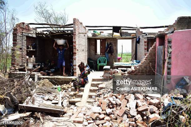 Resident collects belongings from inside a house destroyed by the cyclone "Fani" in Puri in the eastern Indian state of Odisha on May 11, 2019 - At...