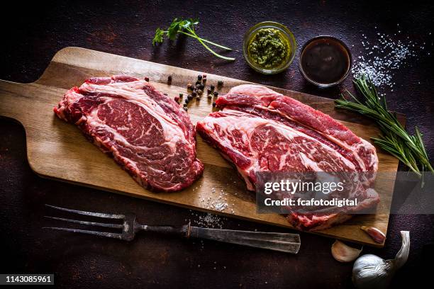 top view of two raw beef steaks on cutting board - fillet steak stock pictures, royalty-free photos & images