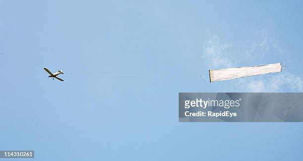 plane towing blank banner - bord bericht stockfoto's en -beelden