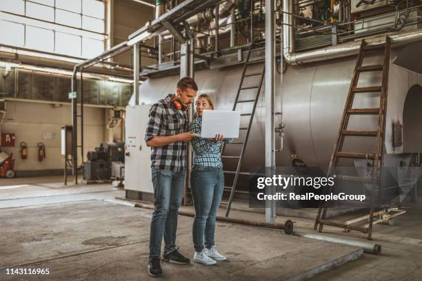 young technicians are inspecting heating system in boiler room - district heating stock pictures, royalty-free photos & images