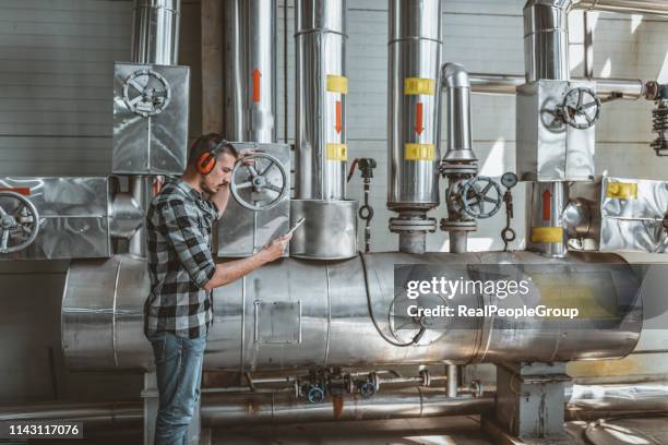 jonge technicus is het controleren van verwarmingssysteem in ketel kamer - gasturbine stockfoto's en -beelden