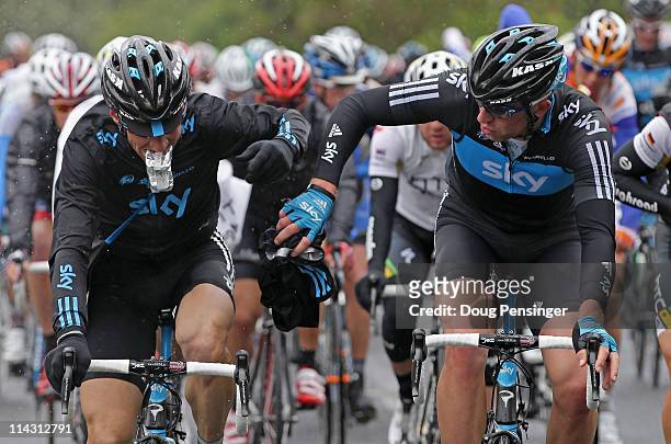 Kurt-Asle Arvesen of Norway and teammate Ian Stannard of Great Britain riding for Sky Procycling eat and change clothes after passing through the...