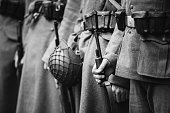 Re-enactors Dressed As World War II German Wehrmacht, Soldiers Standing Order With Rifle Weapons In Hands. Photo In Black And White Colors. Soldiers Holding Weapon Rifles