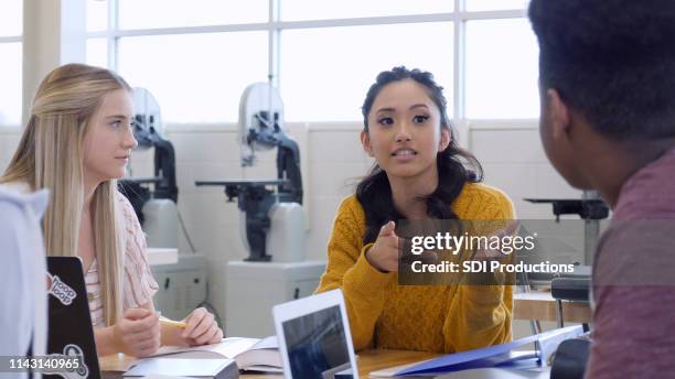 teenage girl gestures as she speaks to classmate - debate imagens e fotografias de stock