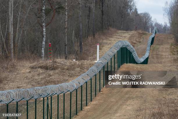 The Latvian-Russian border near Pasiene, eastern Latvia, is pictured on April 10, 2019. - A Latvian border guard helicopter hovers over a vast forest...