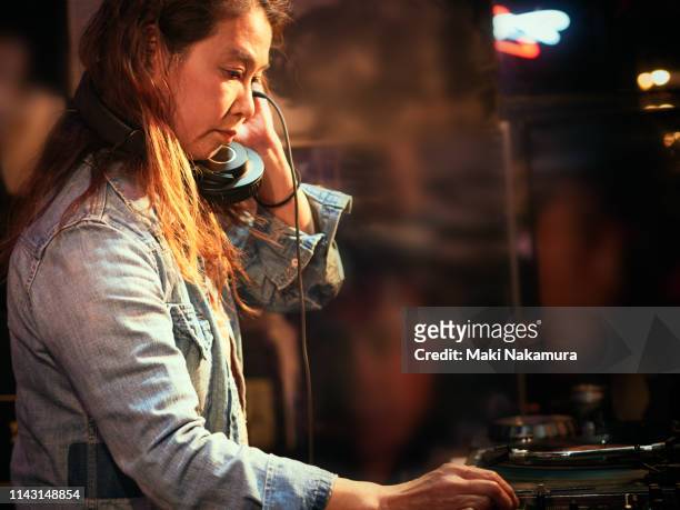 stylish female dj playing using turntable in nightclub - dj portrait stock pictures, royalty-free photos & images