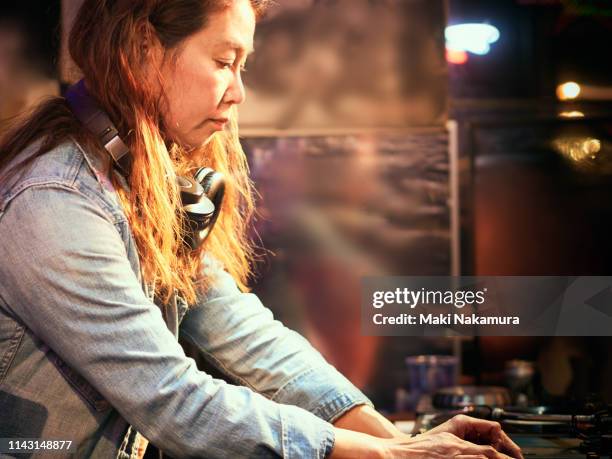 stylish female dj playing using turntable in nightclub - dj portrait ストックフォトと画像