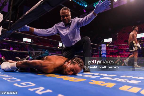 Referee Brent Bovell calls an end to the fight after Kevin Womack Junior knocks out Mark Duncan in the third round during their super middleweight...