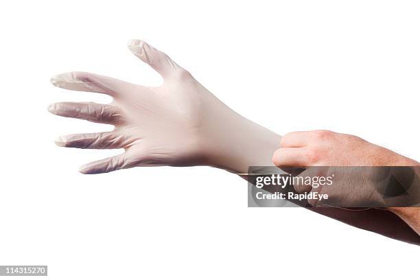 putting en guante quirúrgico - látex fotografías e imágenes de stock