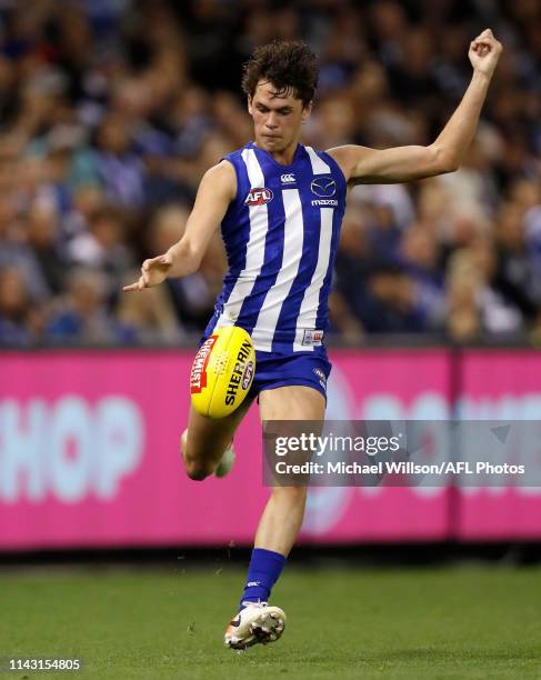 Debutant, Curtis Taylor of the Kangaroos kicks the ball during the 2019 AFL round 08 match between the North Melbourne Kangaroos and the Geelong Cats...