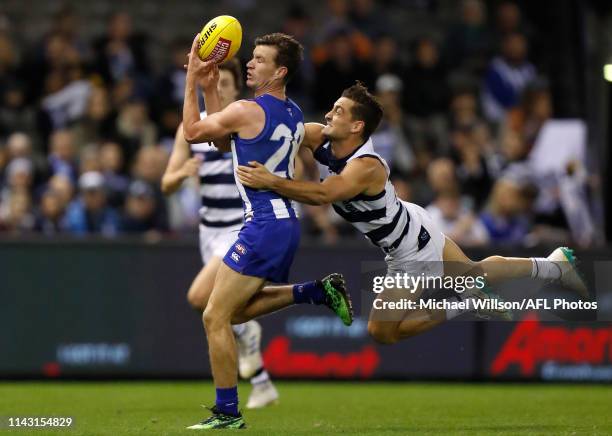 Kayne Turner of the Kangaroos and Luke Dahlhaus of the Cats compete for the ball during the 2019 AFL round 08 match between the North Melbourne...