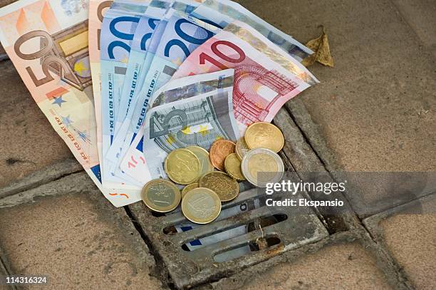 euros down the drain - euros and trash stockfoto's en -beelden