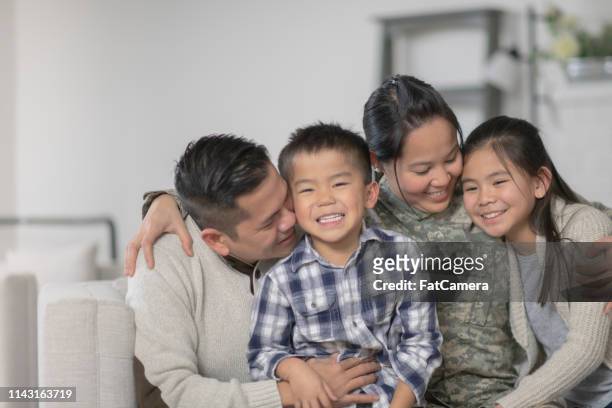 military family sitting on couch - filipino family reunion stock pictures, royalty-free photos & images