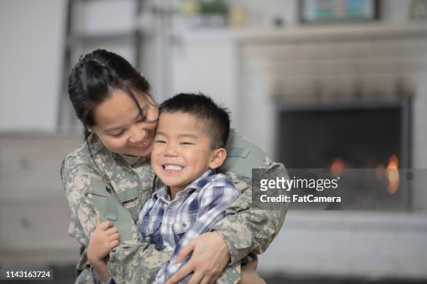 mamma militare che abbraccia suo figlio - filipino family reunion foto e immagini stock