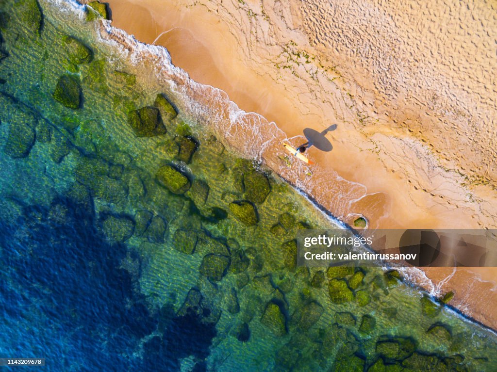 Vista aérea del surfista que va al mar