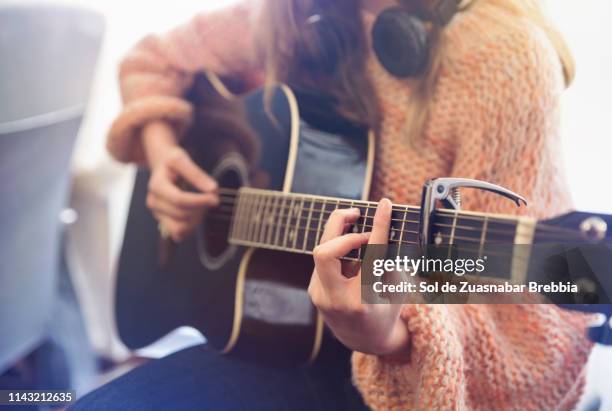 close up of girl's hands playing the guitar - gitaar stockfoto's en -beelden