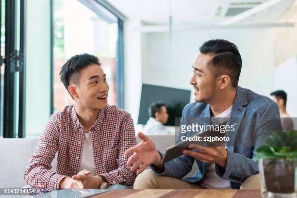 asian young people talking about business - asia stockfoto's en -beelden
