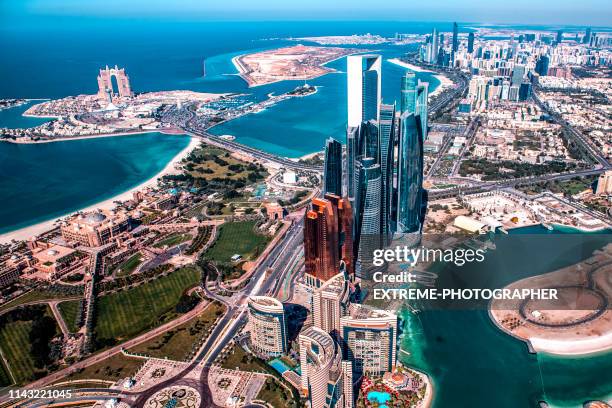 mooie hoge hoek uitzicht op de moderne wolkenkrabbers in abu dhabi, genomen uit een helikopter. marina is ook zichtbaar verder terug - abu dhabi stockfoto's en -beelden