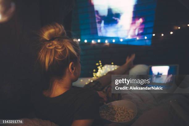 young woman watching movies in home theater - só mulheres jovens imagens e fotografias de stock