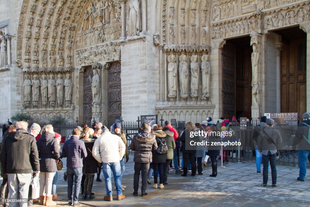 Tourists waiting in line to visit Notre Dame de Paris cathedral