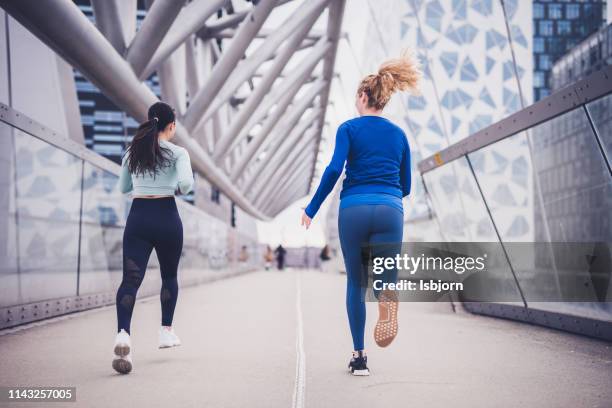 two girlfriends jogging in the city centre. - oslo train stock pictures, royalty-free photos & images