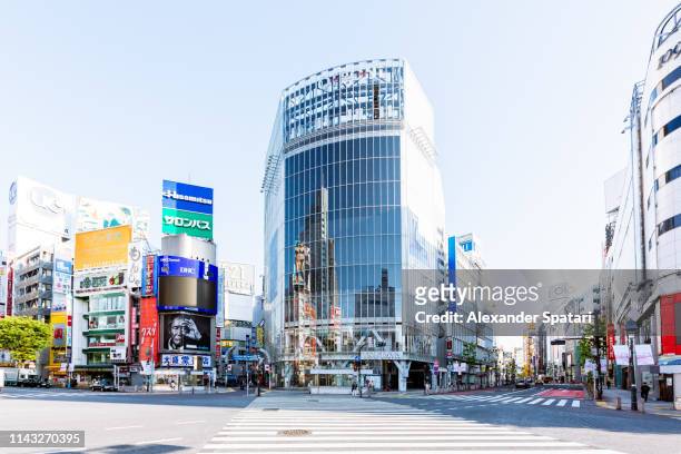 shibuya crossing on a sunny morning with clear blue sky, tokyo, japan - stadsdeel stockfoto's en -beelden