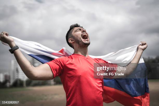 männlicher fan hält russische fahne - russia 2018 flag stock-fotos und bilder