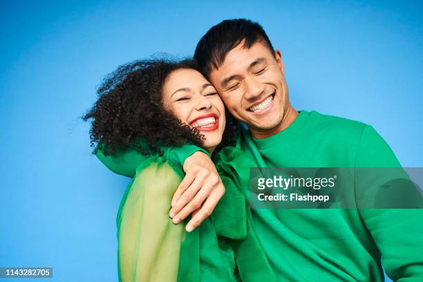 colourful studio portrait of a young woman and man - colored background stockfoto's en -beelden