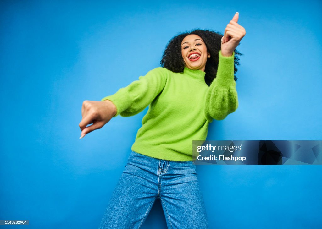 Colourful studio portrait of a young woman dancing