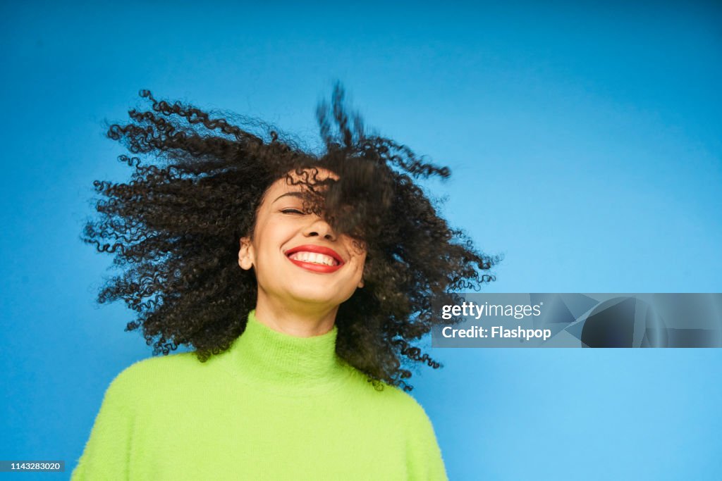 Colourful studio portrait of a young woman dancing