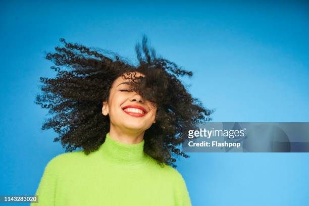 colourful studio portrait of a young woman dancing - curly hair foto e immagini stock