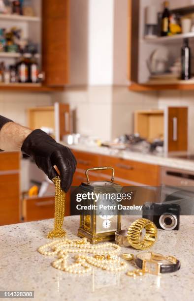 burglar with hoard in kitchen - jewelry robbery stock pictures, royalty-free photos & images