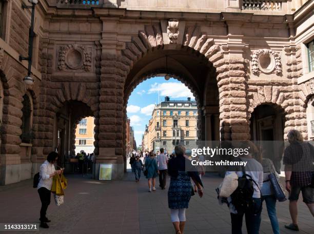 les gens passant par une arche dans les édifices du parlement suédois, stockholm - sveriges riksdag photos et images de collection