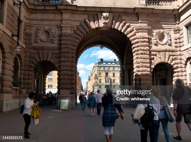 people passing through an archway at the swedish parliament buildings, stockholm - parliament house stockholm stock pictures, royalty-free photos & images